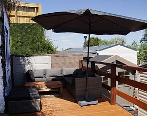 Terras met parasol in Zee en duin vakantiehuis, IJmuiden, met uitzicht op de Noordzeekust.