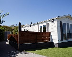 Zee en duin chalet in IJmuiden met omheind terras en kunstgras aan de Noordzeekust.