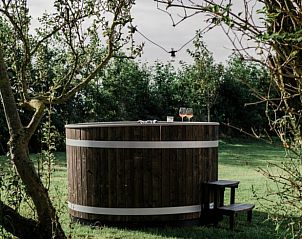 Rustieke hot tub in de tuin van Vakantiehuis in Burgerbrug, omgeven door natuur, Noordzeekust.