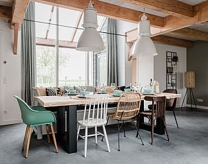 Stijlvolle eetruimte in Vakantiehuis in Burgerbrug met houten tafel en diverse stoelen, Noordzeekust.