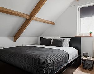 Knusse slaapkamer in Vakantiehuis in Burgerbrug met houten balken, Noordzeekust, Noord-Holland.