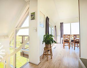 Ruime woonkamer in vakantiehuis NH064, Burgerbrug, Noordzeekust, Noord-Holland met uitzicht op terras.