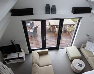 Lichte woonkamer met uitzicht op terras in Sandepark 29 vakantiehuis, Groote Keeten, Noordzeekust, Noord-Holland.