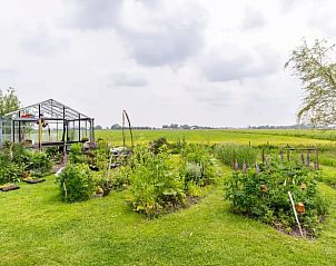 Uitgestrekte tuin met kas in Huisje in Schagerbrug, vakantiehuis aan de Noordzeekust.
