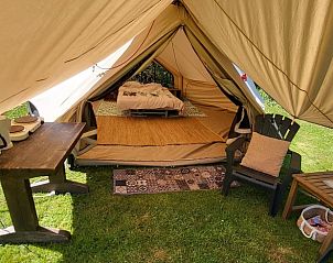 Binnenruimte van de glamping tent bij Huisje in Schagerbrug, Noord-Holland, met zitgedeelte en eethoek voor comfort.