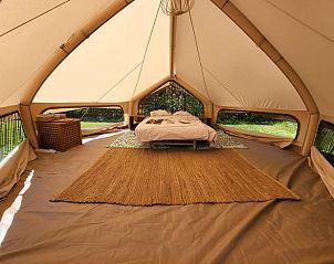 Luxe tentinterieur bij Huisje in Schagerbrug, Schagerbrug, met een gezellig bed en veel natuurlijk licht.