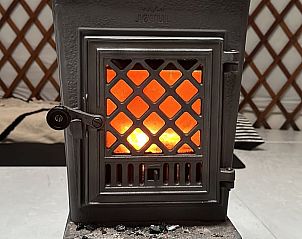 Houtkachel met warme gloed in Vakantiehuisje in Schagerbrug, Noordzeekust, Noord-Holland.