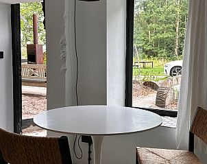 Intieme eetruimte in Vakantiehuisje in Schagerbrug, Noordzeekust, Noord-Holland met uitzicht op de tuin.