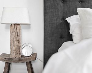 Gemtliche Ecke in der Villa Beau Lieu, Mons, mit Nachttisch aus Holz und moderner Lampe neben dem bequemen Bett.