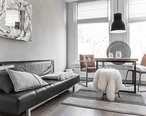 Stilvolle Sitzecke in der Villa Beau Lieu, Bergen, Nordseekste, mit Ledersofa und dekorativen Elementen.