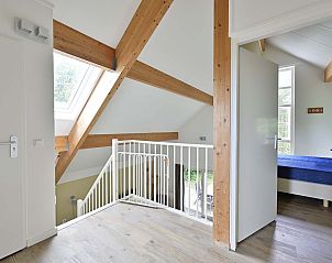 Bovenverdieping met houten balken in vakantiehuis Julianadorp aan Zee.