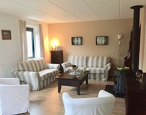 Comfortabele woonkamer in Huis op Duynopgangh, Julianadorp, vakantiehuis aan de Noordzeekust met zachte banken en warme sfeer.