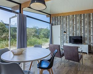 Lichte en moderne woonkamer van Sea House Royal vakantiehuis in Overveen, Noordzeekust, met uitzicht op de natuurlijke omgeving.