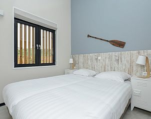 Gezellige slaapkamer in Sea House Royal vakantiehuis, Overveen aan de Noordzeekust, Noord-Holland, met comfortabel bed en rustieke decoratie.