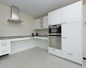 Moderne keuken in Sea House Special vakantiehuis, Overveen, Noordzeekust, Noord-Holland, met strakke witte kasten en roestvrijstalen apparatuur.