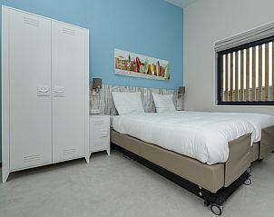 Gezellige slaapkamer in Sea House Special, vakantiehuis aan de Noordzeekust in Overveen, Noord-Holland, met rustieke houten accenten.