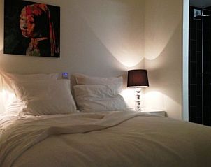 Gezellige slaapkamer in vakantiehuis Droompark Spaarnwoude, Halfweg, Noord-Holland met sfeervolle verlichting.