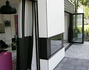 Ruime veranda van vakantiehuis Droompark Spaarnwoude, Halfweg, met toegang tot groene buitenruimte.