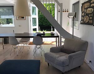 Moderne woonkamer in Vakantiehuis in Andijk met uitzicht op de tuin, perfect voor een rustig verblijf.