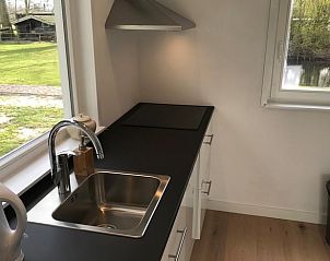 Moderne keuken in Vakantiehuis in Andijk met uitzicht op de groene omgeving, ideaal voor kookliefhebbers.