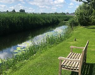 Rustgevend uitzicht op de sloot bij Vakantiehuis in Andijk, omgeven door groene natuur.