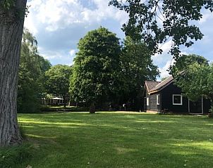 Uitgestrekte tuin bij Vakantiehuis in Andijk, perfect voor een ontspannen verblijf in Noord-Holland.