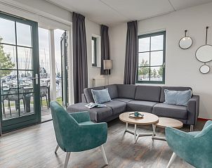Lichte woonkamer van VO7B Comfort bungalow in Volendam, Noord-Holland, met uitzicht op de jachthaven aan de IJsselmeerkust.