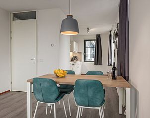 Stijlvolle eetkamer in VO4 Comfort bungalow, Volendam, IJsselmeerkust. Moderne inrichting met houten tafel en turquoise stoelen voor een gezellig verblijf.