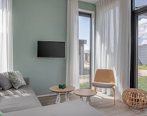 Gezellige zithoek in Lodge 4A in Wijdenes met uitzicht op de groene omgeving van de IJsselmeerkust.