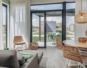 Eetruimte in Lodge 4A te Wijdenes, met rieten stoelen en een open uitzicht op het terras aan de IJsselmeerkust.