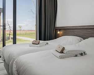 Slaapkamer in Lodge 4B, vakantiehuis aan de IJsselmeerkust, Wijdenes, met comfortabele bedden en een serene sfeer.