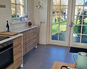 Keuken met uitzicht op tuin in Huisje in Wijdenes, vakantieaccommodatie in Noord-Holland.