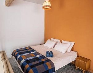 Knusse slaapkamer in Vakantiehuis in Hem, IJsselmeerkust, Noord-Holland met kleurrijke deken.