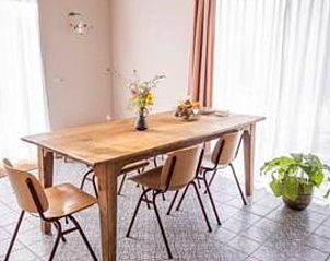 Eettafel met bloemen in Vakantiehuis in Hem, Noord-Holland met veel natuurlijk licht.