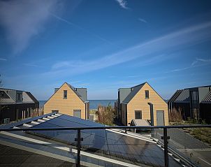 Uitzicht vanaf de Vrijstaande woning in Enkhuizen, met zicht op het IJsselmeer en moderne vakantiehuizen in Noord-Holland.