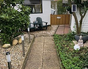 Gezellig terras bij chalet Laat je ziel bungelen, met comfortabele stoelen en groene omgeving in Onderdijk, Noord-Holland.