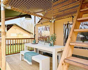 Ruim terras van safaritent 6-8ST in Huizen, met eethoek en uitzicht op de natuur.