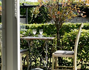 Genieen Sie einen entspannten Moment auf der Terrasse von Huisje in Opperdoes, einem Ferienhaus an der IJsselmeerkste in Nordholland.