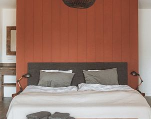 Gemtliches Schlafzimmer in Cottage in Opperdoes, Ferienhaus an der IJsselmeerkste, Nordholland, mit rustikalen Holzakzenten und warmen Farbtnen.