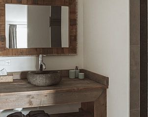 Stilvolles Badezimmer des Huisje in Opperdoes, Ferienhaus in Opperdoes, Nordholland mit rustikalem Holzwaschbecken und modernem Spiegel.