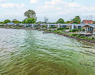 Rij vakantiehuizen langs de IJsselmeerkust bij Vakantiehuis Pavilion Waterfront 4 in Bovenkarspel, Noord-Holland.
