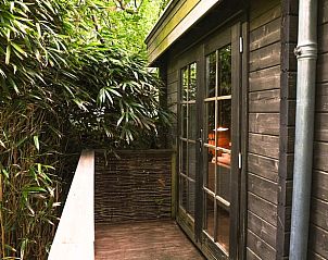 Gezellig terras bij Vakantiehuis in Schellinkhout, omgeven door weelderige natuur.