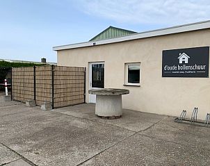 Buitenkant van De oude Paardenstal, appartement in Sint Maartensvlotbrug, met een uitnodigend terras en landelijke charme.