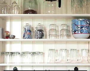 Keukenkast met glazen en servies in Huisje in Oudesluis, vakantiehuis in Noord-Holland, perfect voor een comfortabel verblijf.