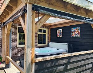 Bubbelbad op de veranda van Huisje in Oudesluis, vakantiehuis in Noord-Holland, voor ultieme ontspanning.