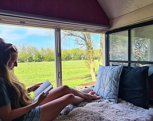 Ontspannen lezen bij het raam met uitzicht op de natuur in Vakantiehuis in Oudesluis, Noord-Holland.