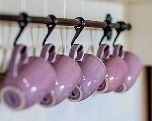 Stijlvolle paarse mokken in de keuken van Vakantiehuis in Oudesluis, Noord-Holland.