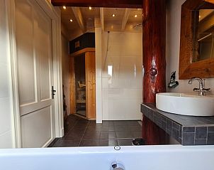 Moderne badkamer met bad en douche in Vakantiehuis in Oudesluis, Noord-Holland.