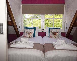 Comfortabele slaapkamer met uitzicht op groen in Vakantiehuis in Oudesluis, Noord-Holland.