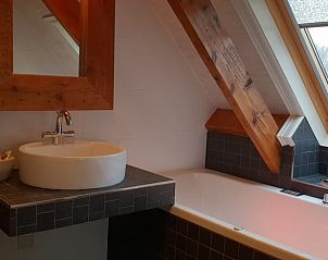 Badkamer met houten accenten in Vakantiehuis in Oudesluis, Noord-Holland voor een rustieke uitstraling.